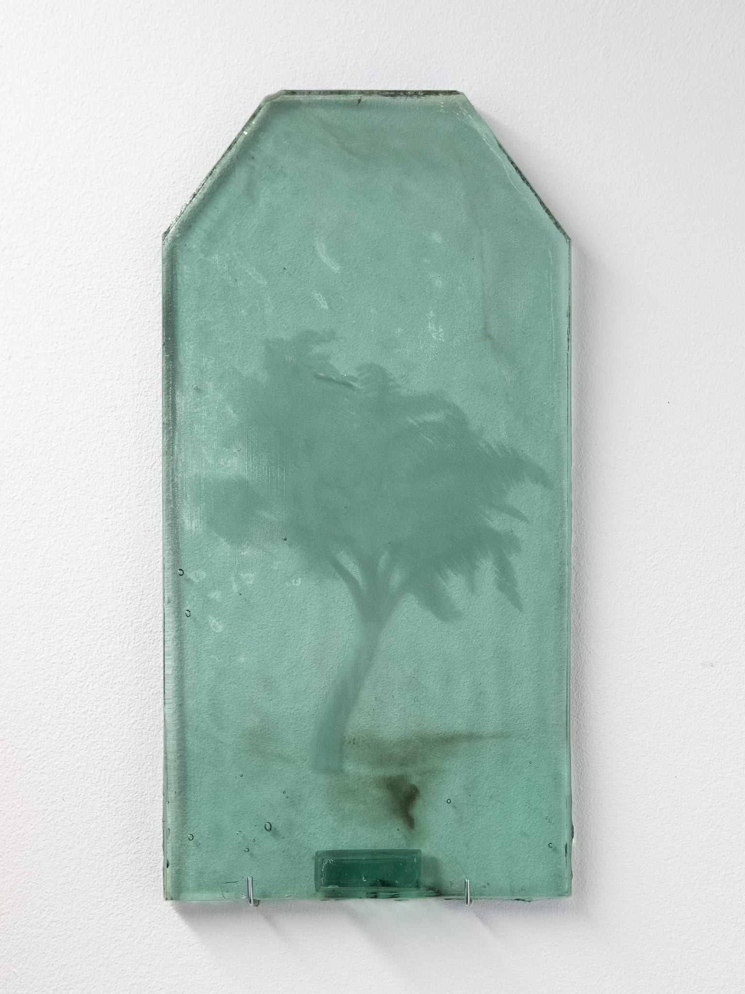 A collection of engraved glass tiles leaning against a wall.