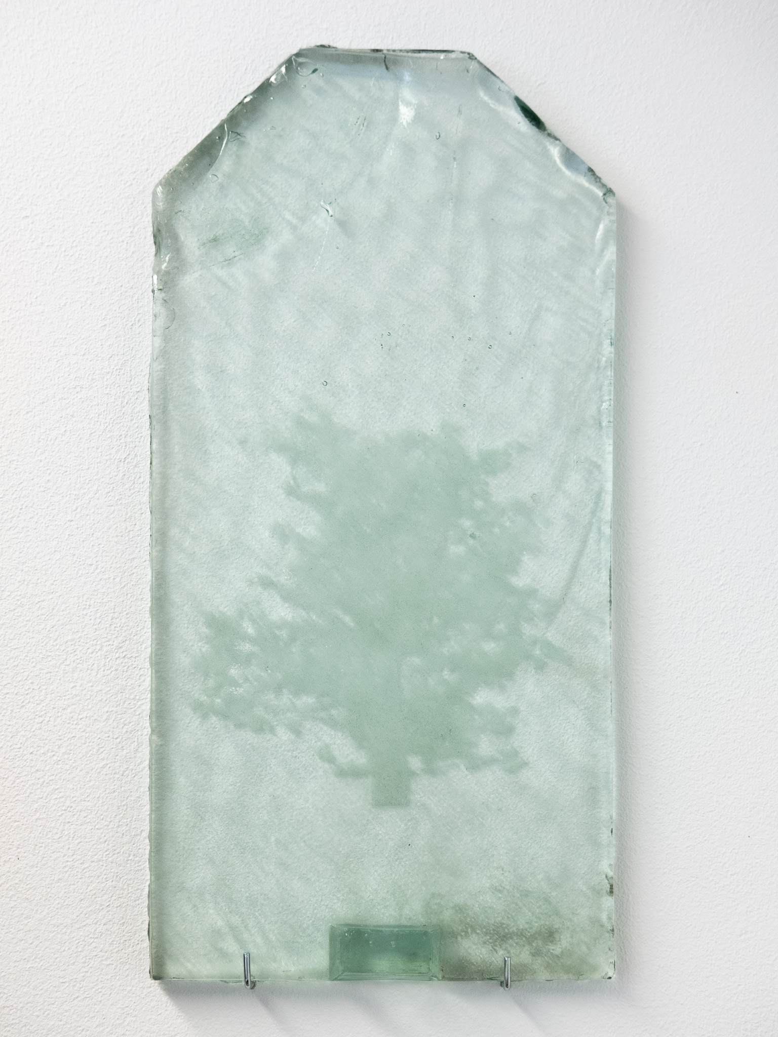 An engraved glass tile on a textured surface.